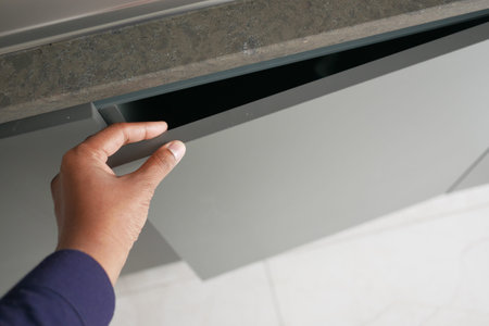 mans hand open drawer wooden in cabinet