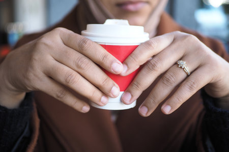 women holding a take away kraft coffee cupの写真素材