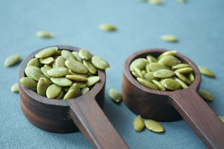 Pumpkin seeds in wooden spoon on tableの写真素材