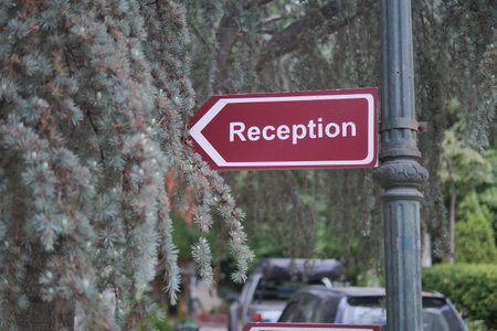 white and red direction arrow sign with reception text on itの写真素材
