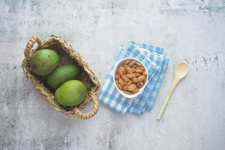 top view of slice of avocado and almond nut on table