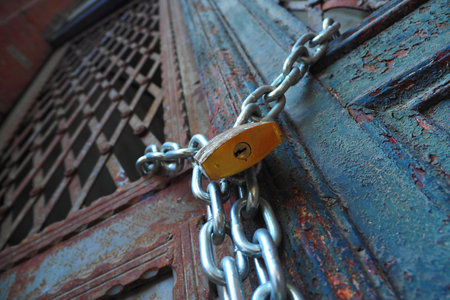 Closed old rusty lock on a wooden doorの写真素材