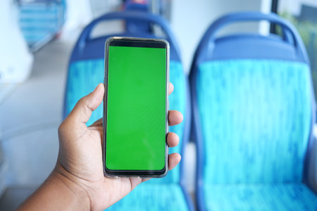 young man hand using smart phone with green screen inside of metro trainの写真素材