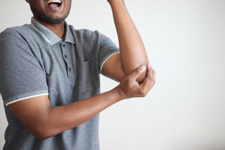 young man suffering pain on elbowの写真素材