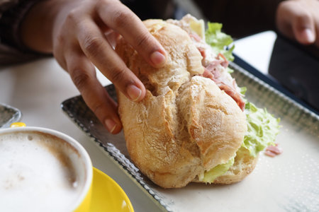 hand holding beef burger on table close up