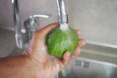 hand washing avocado with water sprinklingの写真素材