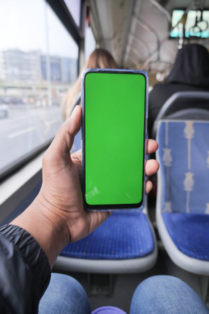 young man hand using smart phone with green screen inside of metro trainの写真素材