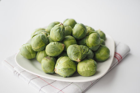 Fresh brussels sprouts in a box on a white backgroundの写真素材