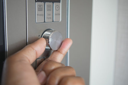 Close up of men hand setting temperature control on oven.