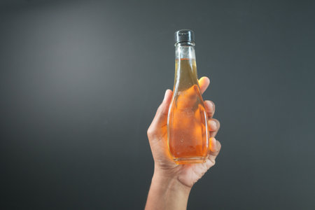 holding a bottle of apple vinegarの写真素材