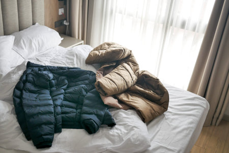 messy bed with cloths in early morning , messy bed after waking up