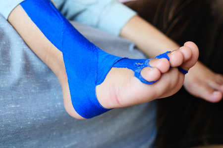 Elastic therapeutic blue tape applied to child leg. Kinesio Taping therapy for injuryの写真素材
