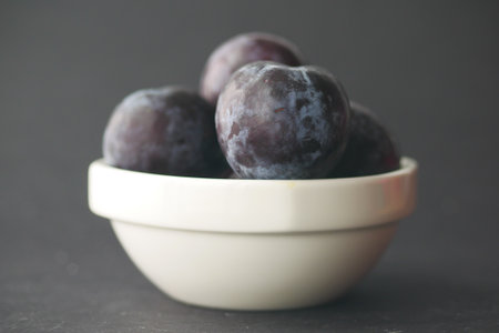 Fresh plums in a bowl on tableの写真素材