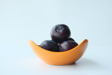 Fresh plums in a bowl on tableの写真素材