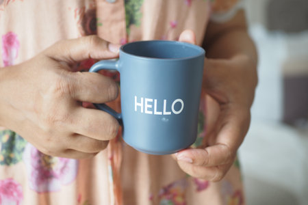 women holding a blue coffee cup with hello wordの写真素材