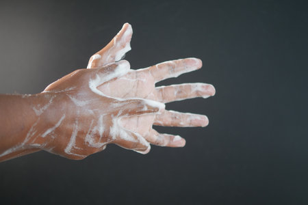 young man washing hands with soap warm waterの写真素材