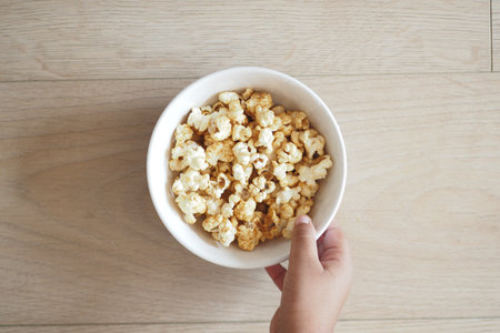 top view of child hand holding a bowl of popcornの写真素材