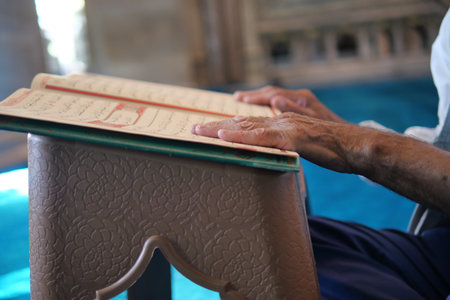 muslim man hand holding Holy book Quran at mosque