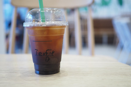 Iced Americano in plastic container on cafe tableの写真素材