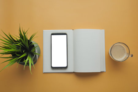 top view of smart phone with empty screen and notepad on tableの写真素材