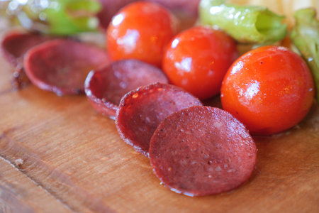 smoked salami sausage and tomato meal on tableの写真素材