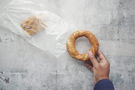 taking a Turkish Bagel Simit out from a plastic packet
