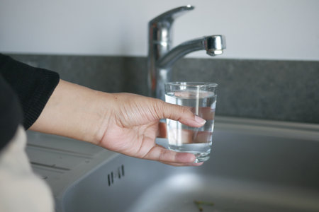 water pouring from a faucet tap in a glass, drinking pure water conceptの写真素材