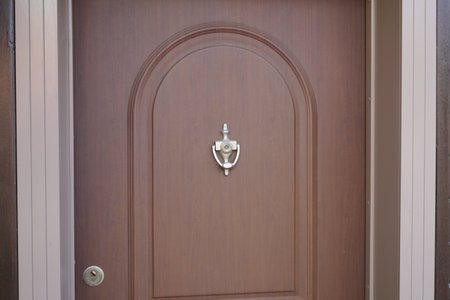 Classic brass door knocker on a wood backgroundの写真素材