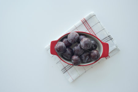 Fresh plums in a bowl on tableの写真素材