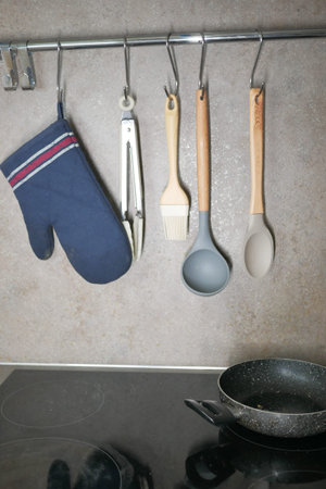 Kitchen utensils hanging on a hanger inside a modern kitchen,