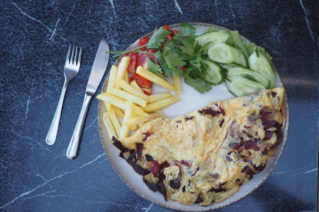 fried egg mixed with sausage served with chips and saladの写真素材