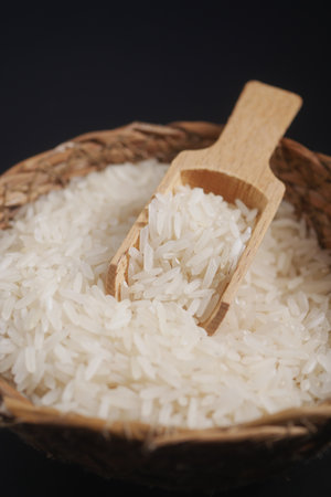 Raw white rice on a wooden spoonの写真素材