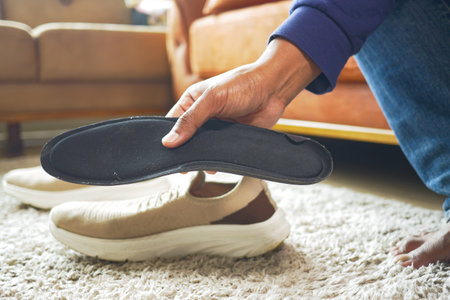 men hand putting Orthopedic insoles in shoesの写真素材