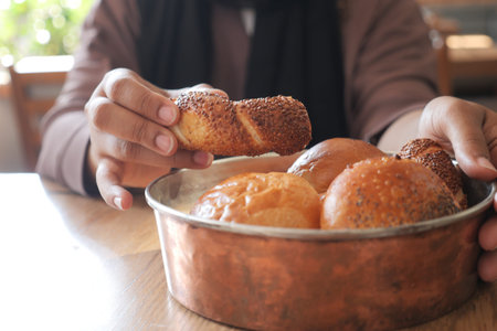 women hand pick baked bun on table