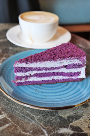 purple velvet cake with cream and coffee on tableの写真素材