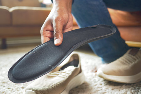 men hand putting Orthopedic insoles in shoes