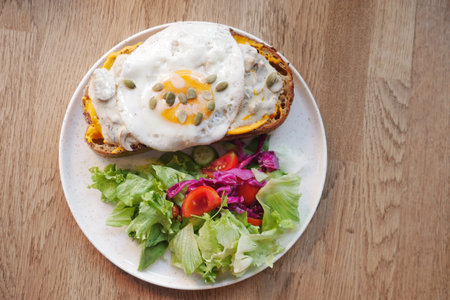 top view of Egg and mushrooms on toast served with fresh salad on a plateの写真素材