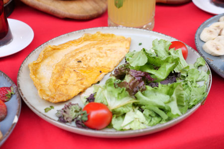Plain Egg Omelette served with fresh salad on tableの写真素材