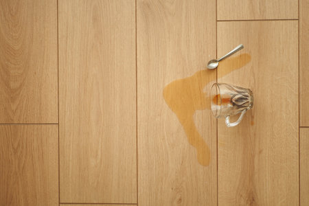 cup of coffee spilled on wooden floorの写真素材