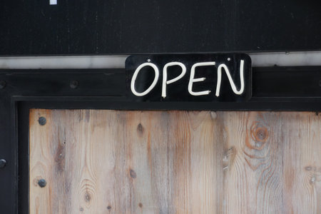 open text on paper hanging on cafe door