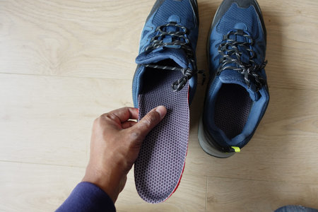 men hand putting Orthopedic insoles in shoesの写真素材
