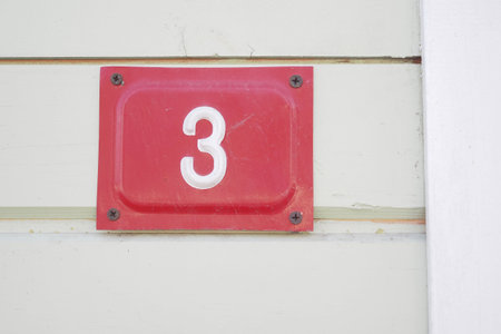 house number three. Decorative lettering on a brick wall.の写真素材