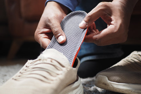 men hand putting Orthopedic insoles in shoesの写真素材