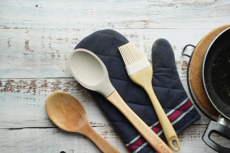 wooden cutlery fork and spoon and cooking pan on tableの写真素材