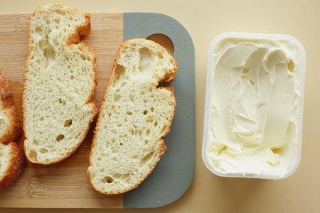 fresh butter in a container with bread on white backgroundの写真素材