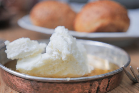 butter cream and honey in a bowl on table .の写真素材