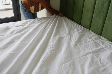 young women making bed at bedroom.