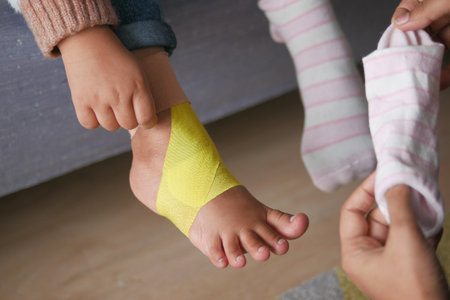 Elastic therapeutic yellow tape applied to child leg.の写真素材