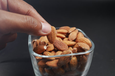 hand pick almond nuts in a bowlの写真素材