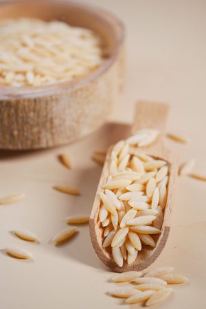 brown long rice in a wooden spoon on table .の写真素材